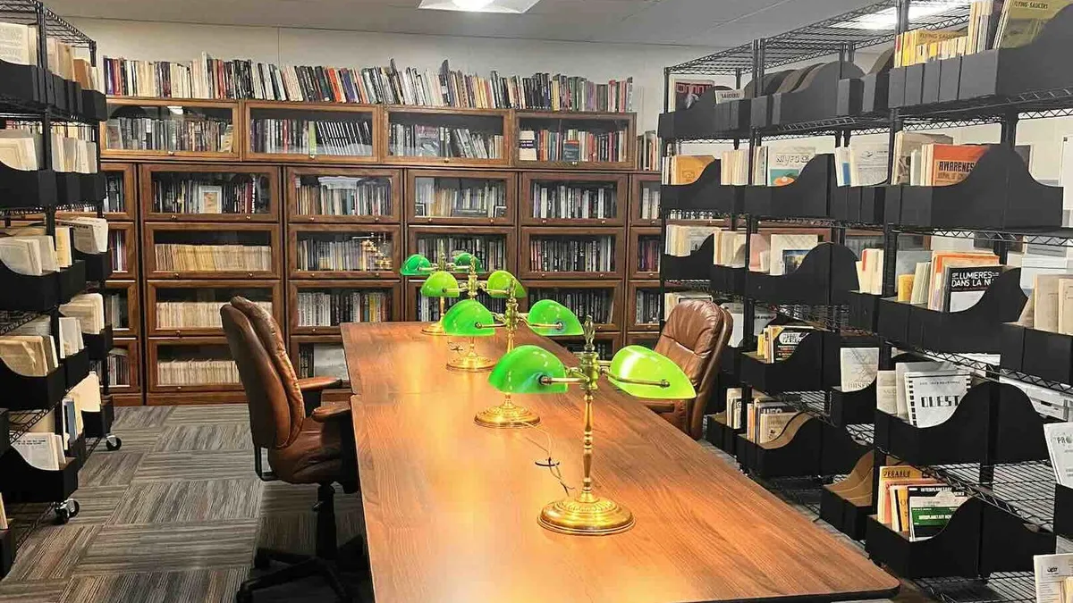 The NUFOHRC reading room in Rio Rancho, with glass-front bookcases and bins of UFO journals