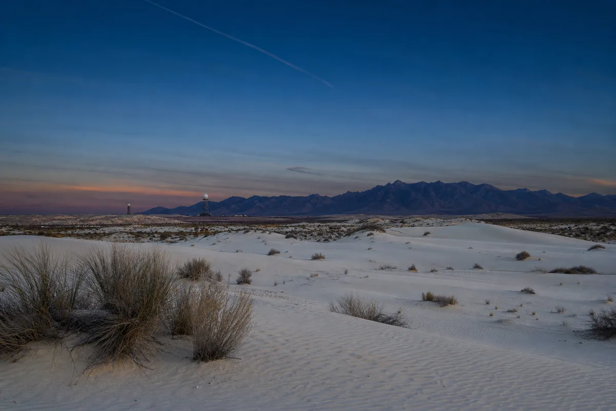 White Sands Missile Range at dusk, pale gypsum dunes under an indigo sky